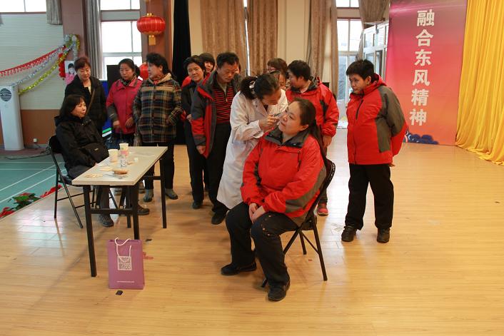 图为为残疾人做“护耳贴”